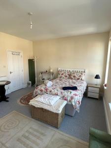 a bedroom with a bed and a table and a door at Number 33 Family Beach Residence in Great Yarmouth