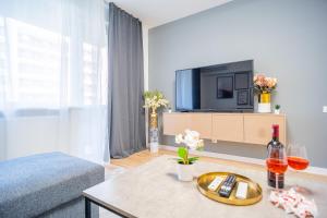 een woonkamer met een bank en een tv bij Refreshingly Chic: Newly Renovated 2BR Apartment in Boekarest