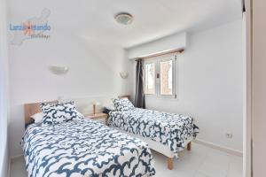 sypialnia z dwoma łóżkami i oknem w obiekcie Vivienda Vacacional Las Coronas 48 w Costa Teguise +15 zdjęć