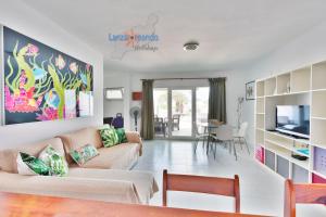 a living room with a couch and a tv at Vivienda Vacacional Las Coronas 48 in Costa Teguise