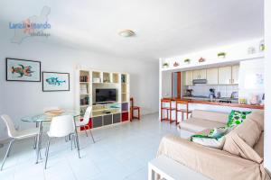 salon z kanapą i stołem w obiekcie Vivienda Vacacional Las Coronas 48 w Costa Teguise