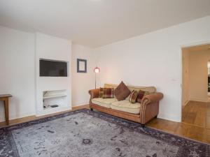 a living room with a couch and a tv at Pass the Keys Chic 1 Bed Flat in Quaint Sunninghill Village in Ascot