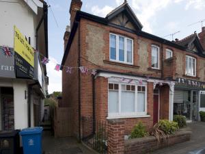 a brick house with a string of flags on it at Pass the Keys Chic 1 Bed Flat in Quaint Sunninghill Village in Ascot