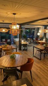 a restaurant with tables and chairs and chandeliers at Le Mont Brouilly in Quincié-en-Beaujolais