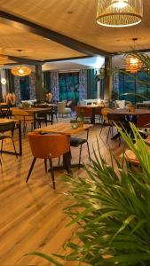 a restaurant with tables and chairs and windows at Le Mont Brouilly in Quincié-en-Beaujolais