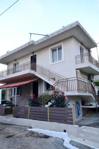 a white house with balconies and flowers on it at Lemar Home in Áno Kremmídhia