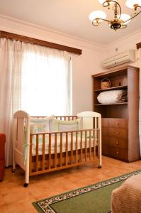 a baby crib in a room with a window at Lemar Home in Áno Kremmídhia