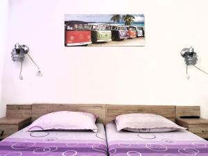 a bed with two pillows and a painting on the wall at Guesthouse "Slavkova" in Sozopol