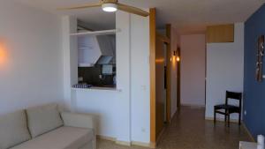 a living room with a couch and a ceiling fan at Apartamentos Paradís Palmyra in Salou
