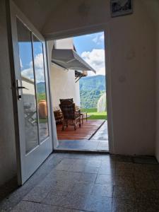 eine offene Tür zu einer Terrasse mit Bergblick in der Unterkunft Studio Lotrist in Radovljica
