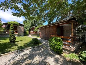 a log cabin with a bench in a yard at Zora Camping - Bungalows in Obzor