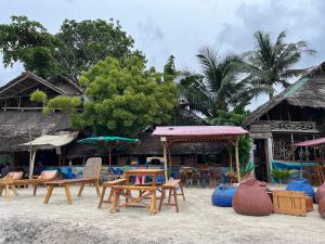 un gruppo di sedie e tavoli sulla spiaggia di Bamboo Nest Beachfront Floating Tent a Città di Puerto Princesa