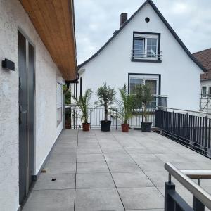 un patio con macetas y una casa blanca en Ferienwohnung Monteurwohnung, en Babenhausen