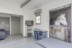 a bedroom with a door with a painting of a horse on it at Hotel Les Palmiers En Camargue in Saintes-Maries-de-la-Mer