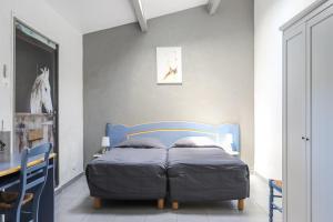 a bed in a bedroom with a blue bed frame at Hotel Les Palmiers En Camargue in Saintes-Maries-de-la-Mer