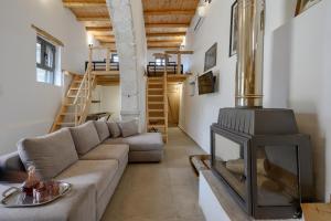 a living room with a couch and a fireplace at Nomas Home Imbros in Khóra Sfakíon