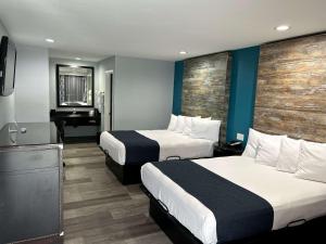 a hotel room with two beds and a piano at SureStay Hotel by Best Western Buena Park Anaheim in Buena Park