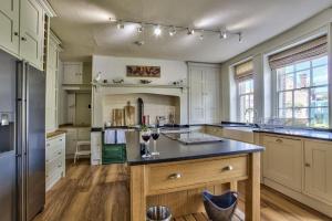 eine Küche mit weißen Schränken und einer schwarzen Arbeitsplatte in der Unterkunft Timberley Farm by Group Retreats in Pulborough