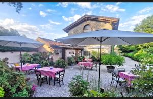 a patio with tables and chairs and umbrellas at Le camere di Virgilio in Monzambano