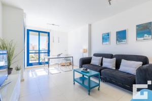 uma sala de estar com um sofá preto e uma mesa em Apartamento Estrella de Calpe 8C - Grupo Turis em Calpe