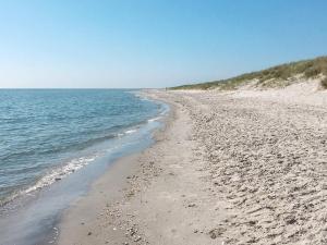 una playa con arena y el océano en un día soleado en 6 person holiday home in S by, en Saeby