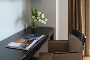 a desk with a chair and a vase with flowers at lebua at State Tower in Bangkok