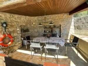 un patio con tavolo, sedie e parete in pietra di Bv-am 001-can Palome. ad Arenys de Munt