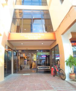 a bike parked in front of a building at Hotel California Suite in Sudtungan
