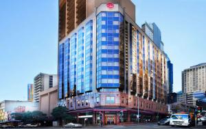 een hoog gebouw met een klok erop bij Metro Hotel Marlow Sydney Central in Sydney
