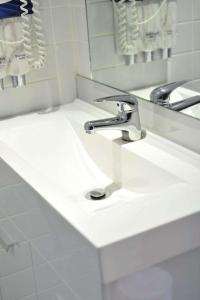 a bathroom sink with a faucet and a mirror at Metro Apartments On Bank Place in Melbourne