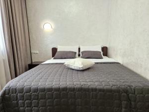 a bedroom with a large bed with two pillows at Apartment on Belvedere in Ivano-Frankivsʼk