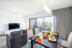 uma sala de estar com um sofá e uma mesa em #090 Fully Equiped with Pool View and Kid Playground em Albufeira