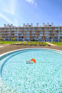 a large swimming pool in front of a building at #090 Fully Equiped with Pool View and Kid Playground in Albufeira