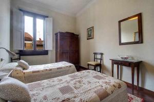1 Schlafzimmer mit 2 Betten, einem Tisch und einem Spiegel in der Unterkunft Spettacolare Vista Duomo Con Terrazza in Florenz