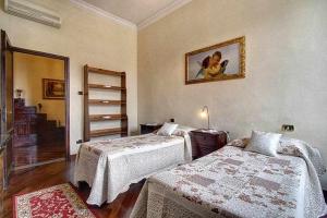 ein Schlafzimmer mit 2 Betten und einem Bild an der Wand in der Unterkunft Spettacolare Vista Duomo Con Terrazza in Florenz