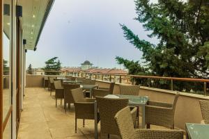 a patio with tables and chairs on a balcony at Vemara City Boutique Hotel-free parking in Varna City