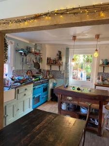 a kitchen with blue cabinets and a wooden table at Bell Hay House in Glastonbury