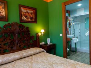 a green bedroom with a bed and a bathroom at La Posta del Camín Real in La Plaza