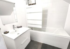 biała łazienka z umywalką i wanną w obiekcie "Colbert Triplex" 3 chambres - Balcon - Patio - Cathédrale w Tours