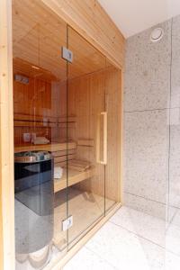uma casa de banho com uma cabina de duche em vidro e um lavatório. em Penthouse Stradom by LoftAffair em Cracóvia