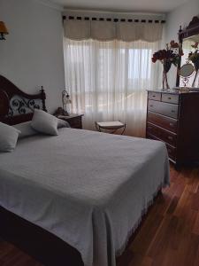 Un dormitorio con una cama y una cómoda y una ventana. en Tarja 1, en Alicante