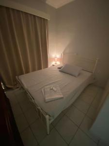 un letto bianco in una stanza con finestra di Handra Apartment Seaview a Città di Kos