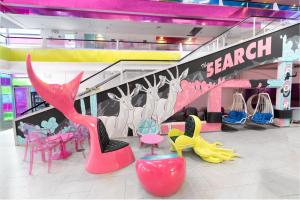a store with colorful chairs and tables and a staircase at Abraham Eilat in Eilat