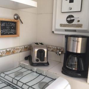 a kitchen with a toaster and a coffee maker on a counter at Sweet and Little Home in Buenos Aires