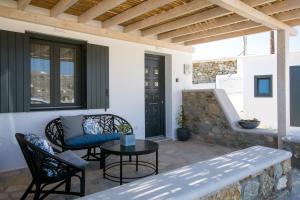 un patio con mesa, sillas y banco en Alko Apartments en Mykonos ciudad