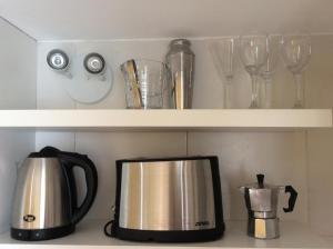 a coffee pot and glasses on a shelf at Sweet and Little Home in Buenos Aires
