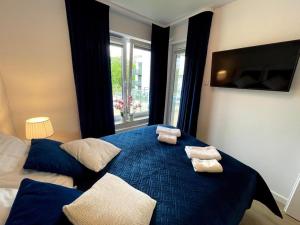 sypialnia z niebieskim łóżkiem i 2 ręcznikami w obiekcie Klif Apartamenty Nadmorskie Tarasy w Kołobrzegu