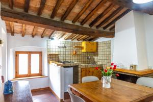a kitchen with a table with a vase of flowers on it at Mansarda Roccatederighi in Roccatederighi +17 photos