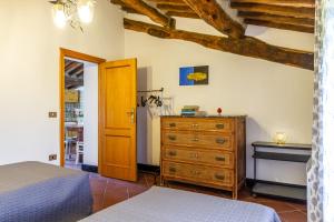 a bedroom with a bed and a wooden dresser at Mansarda Roccatederighi in Roccatederighi