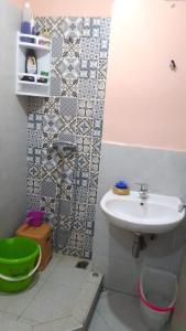 y baño pequeño con lavabo y ducha. en appartement pour famille en Agadir